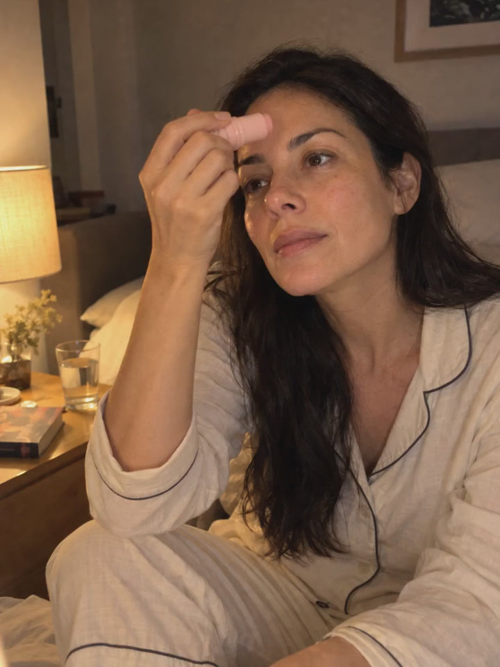 Mujer aplicando el bálsamo en la frente antes de dormir